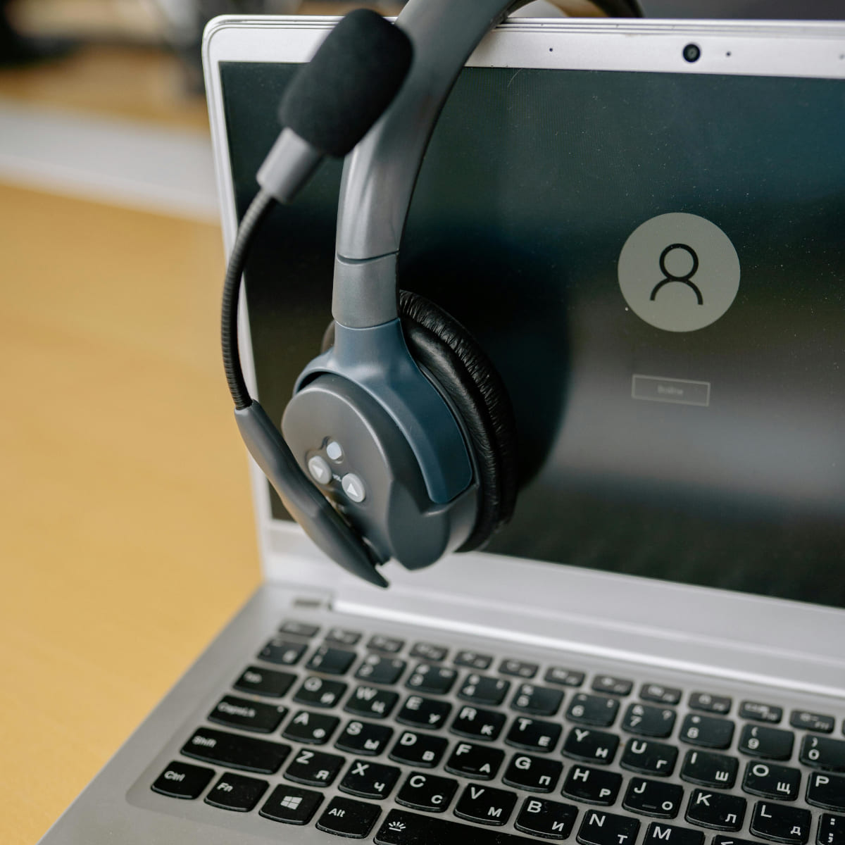 Ordenador portátil con auriculares y micrófono para consultas informáticas