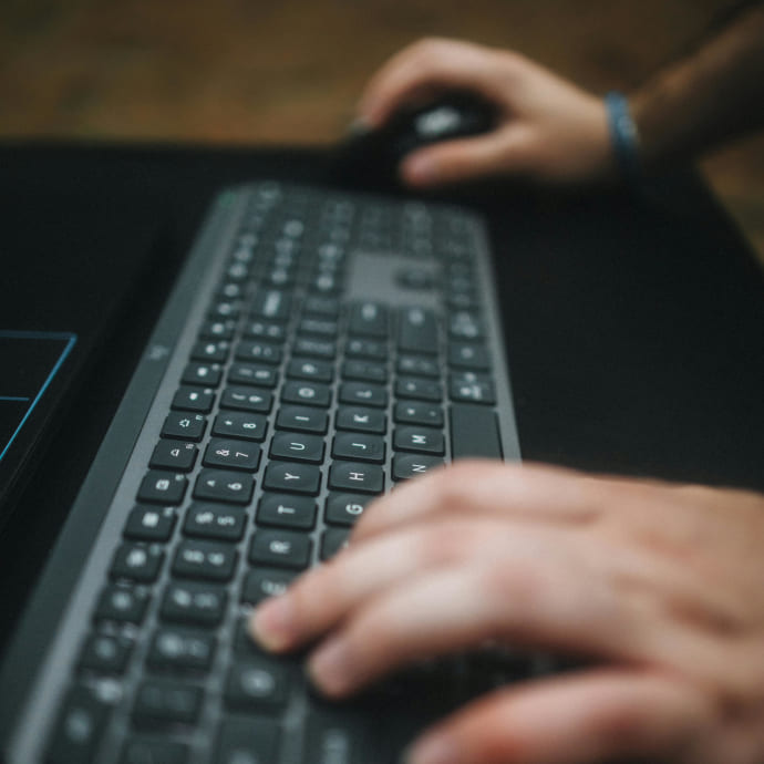 Trabajador usando teclado y ratón en un ordenador